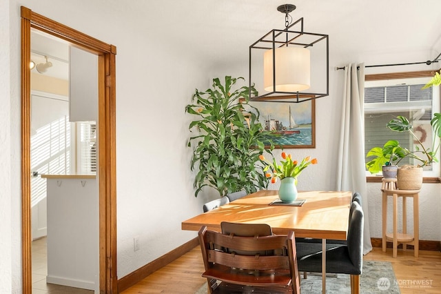 dining area with light wood-style flooring and baseboards