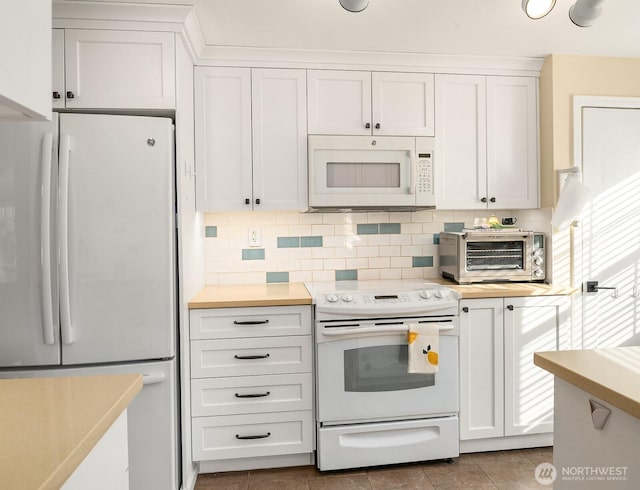 kitchen featuring white appliances, a toaster, light countertops, and backsplash