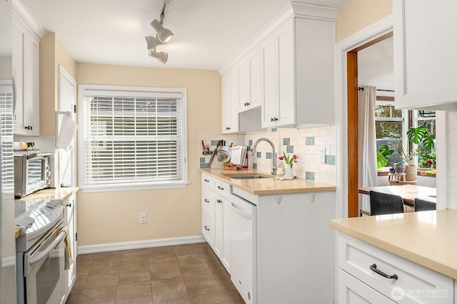 kitchen featuring a sink, backsplash, white appliances, white cabinets, and light countertops