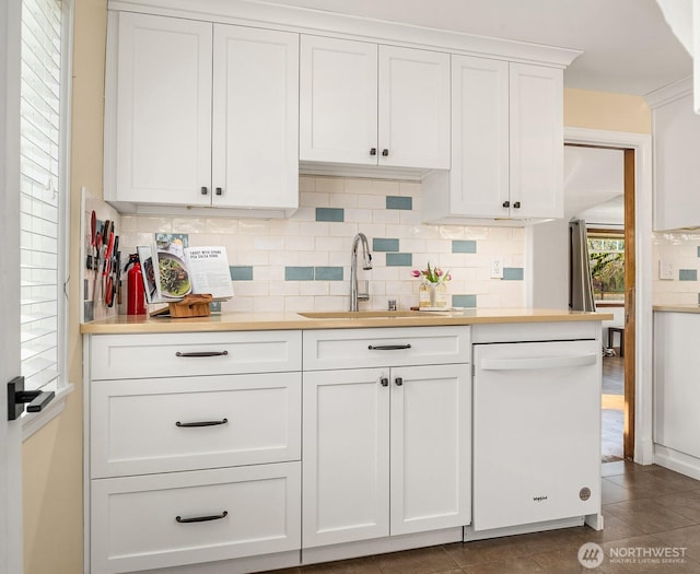 kitchen with dishwasher, white cabinetry, light countertops, and a sink