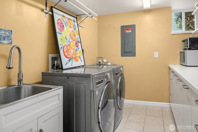 laundry room featuring light tile patterned floors, washing machine and clothes dryer, electric panel, cabinet space, and a sink