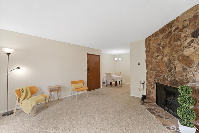 sitting room with carpet flooring, baseboards, an inviting chandelier, and a fireplace