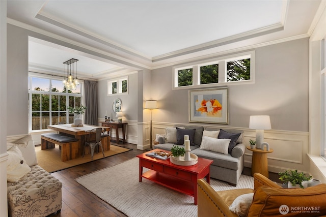 living area featuring a chandelier, wainscoting, a tray ceiling, and hardwood / wood-style flooring