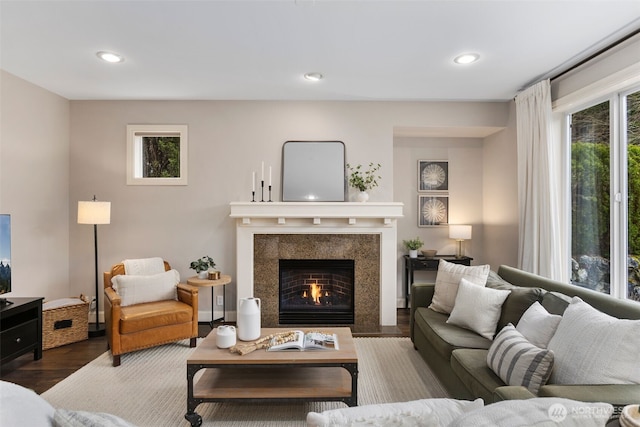 living area with a high end fireplace, recessed lighting, and wood finished floors