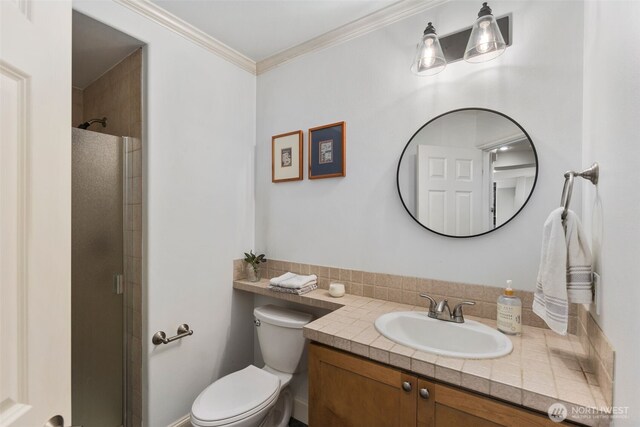 full bathroom with toilet, a stall shower, vanity, and ornamental molding