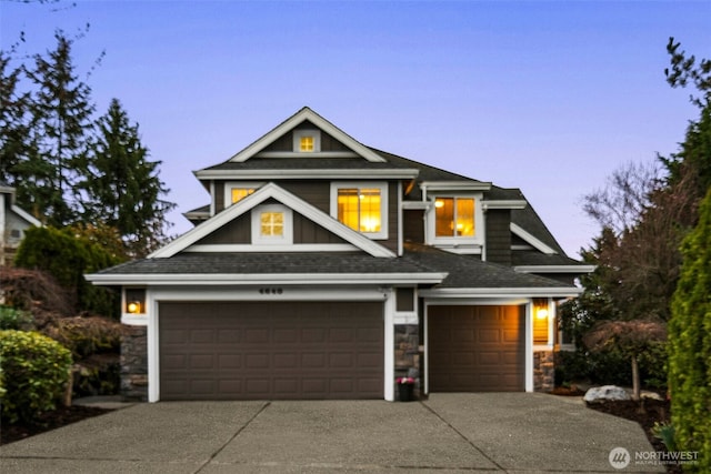 view of front facade featuring a garage, stone siding, and driveway