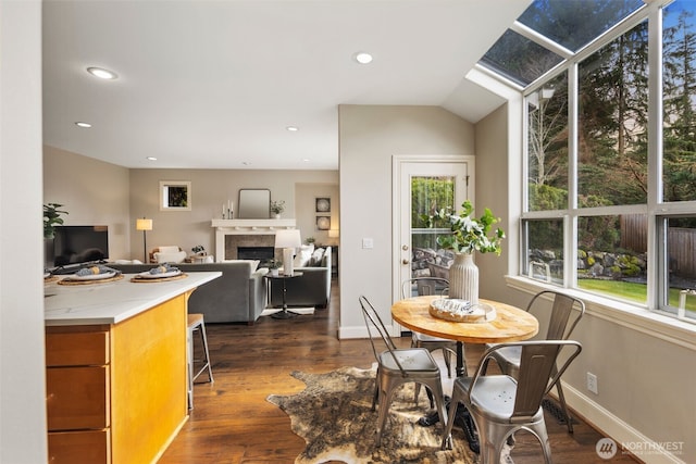 dining space with dark wood-style floors, recessed lighting, a fireplace, and baseboards