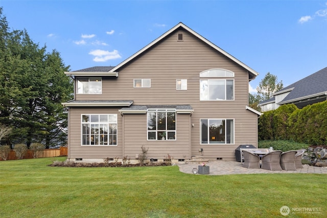 rear view of house featuring crawl space, fence, a lawn, and a patio area