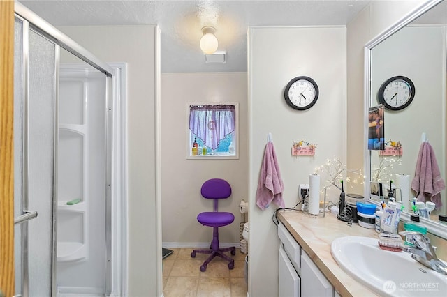 bathroom featuring vanity, baseboards, a stall shower, a textured ceiling, and tile patterned floors