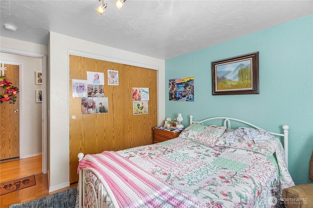 bedroom with a closet, a textured ceiling, and baseboards