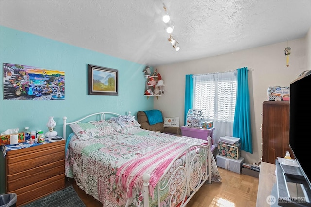 bedroom featuring a textured ceiling and rail lighting