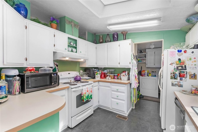 kitchen featuring washer and dryer, white appliances, light countertops, and under cabinet range hood