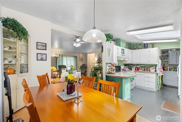 dining space featuring ceiling fan, finished concrete floors, washer / clothes dryer, and a textured ceiling