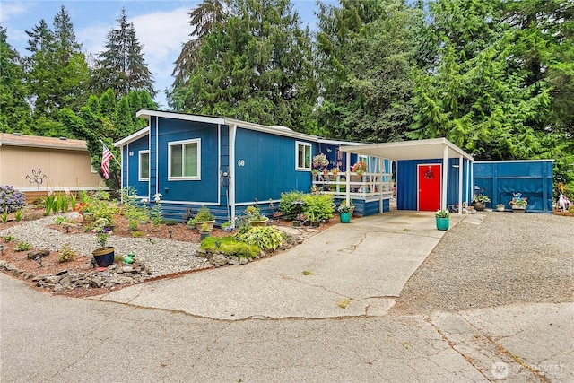 manufactured / mobile home with an attached carport and concrete driveway