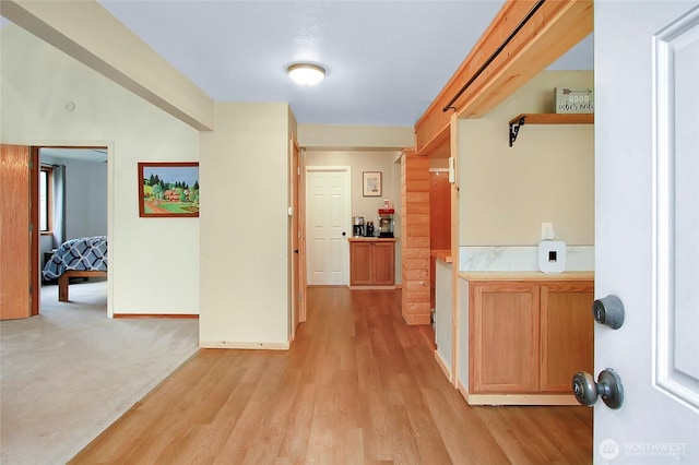 hall featuring baseboards and light wood-style floors