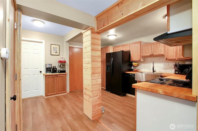 kitchen with light brown cabinets, a sink, black appliances, under cabinet range hood, and light wood-type flooring