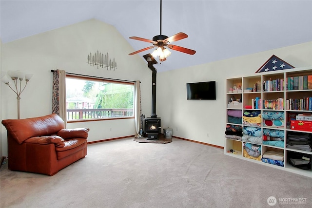 sitting room with high vaulted ceiling, baseboards, carpet, and a wood stove