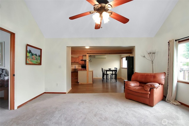 sitting room featuring a wall unit AC, light colored carpet, baseboards, and ceiling fan