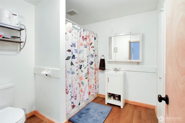 bathroom featuring vanity, wood finished floors, baseboards, curtained shower, and toilet