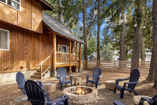 view of patio with an outdoor fire pit and fence