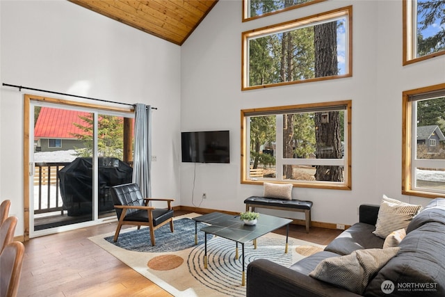 living area with wooden ceiling, wood finished floors, baseboards, and high vaulted ceiling