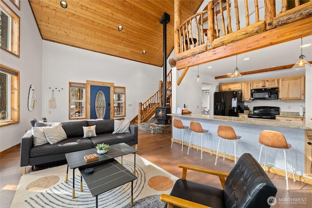 living room featuring stairway, wooden ceiling, a high ceiling, and wood finished floors