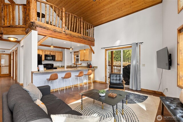 living room with wood finished floors, baseboards, a high ceiling, and wooden ceiling