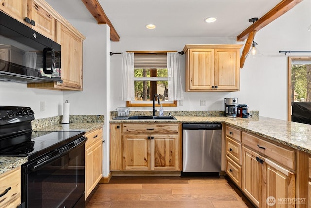 kitchen with a sink, light wood-type flooring, black appliances, and a healthy amount of sunlight