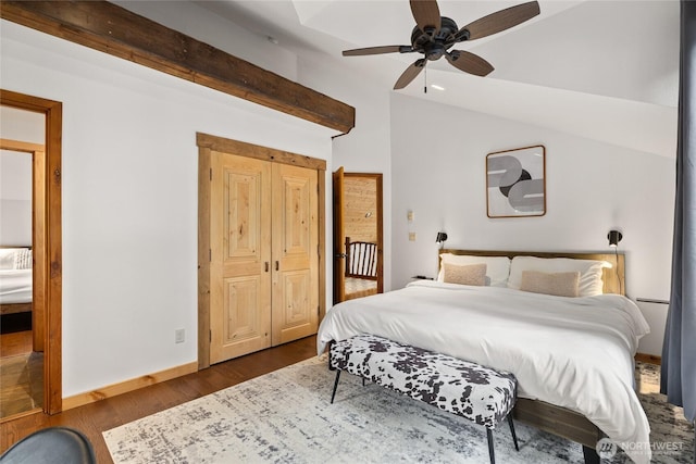 bedroom featuring dark wood finished floors, lofted ceiling, baseboards, and ceiling fan