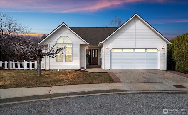 ranch-style house featuring a yard, fence, a garage, and driveway