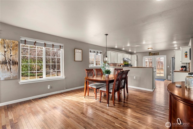 dining room featuring hardwood / wood-style floors, baseboards, visible vents, and french doors