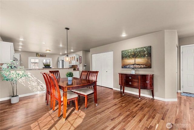 dining area with recessed lighting, light wood-style flooring, and baseboards