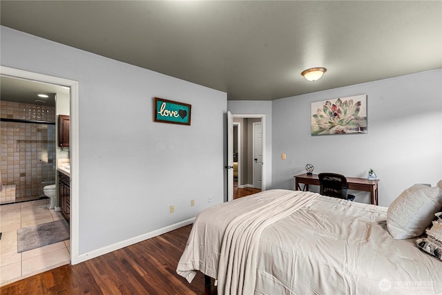 bedroom with wood finished floors, baseboards, and ensuite bathroom