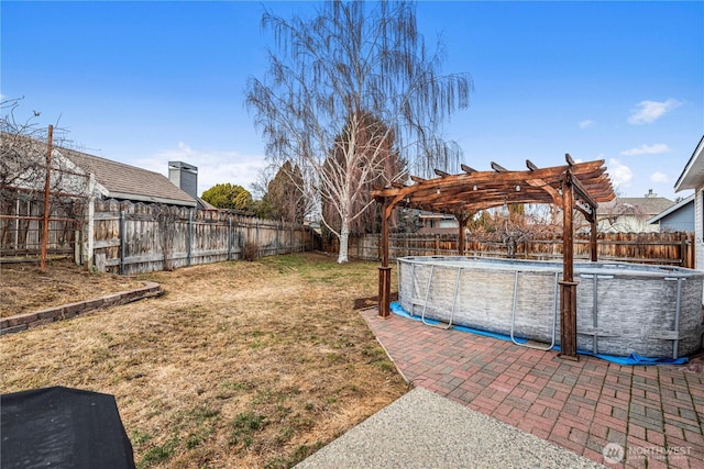 view of yard featuring a patio area, a fenced in pool, a pergola, and a fenced backyard