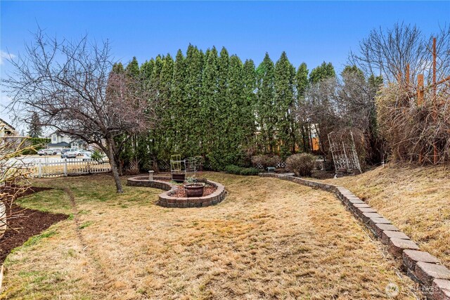 view of yard featuring fence and a fire pit