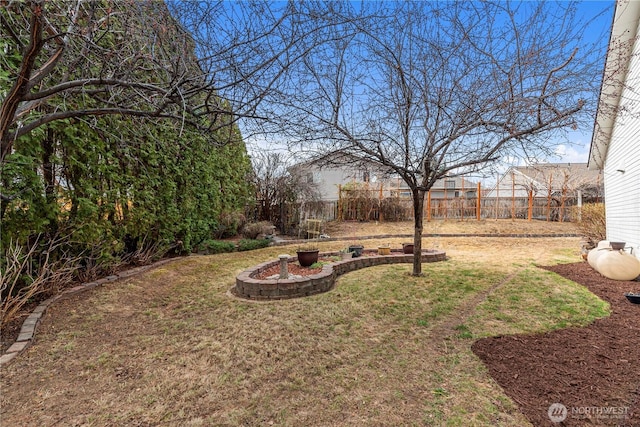 view of yard with a fire pit and fence