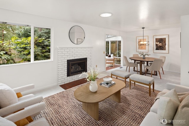 carpeted living area featuring baseboards and a brick fireplace