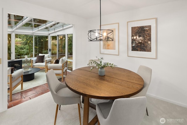 dining room with carpet flooring, plenty of natural light, and baseboards