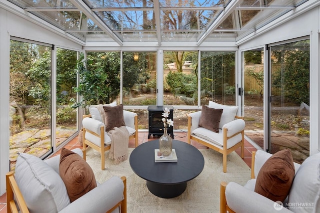 sunroom featuring a wood stove and plenty of natural light