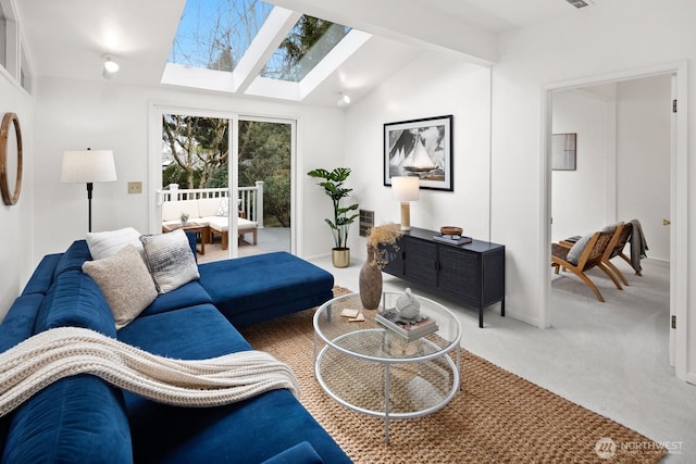 carpeted living room featuring vaulted ceiling with skylight