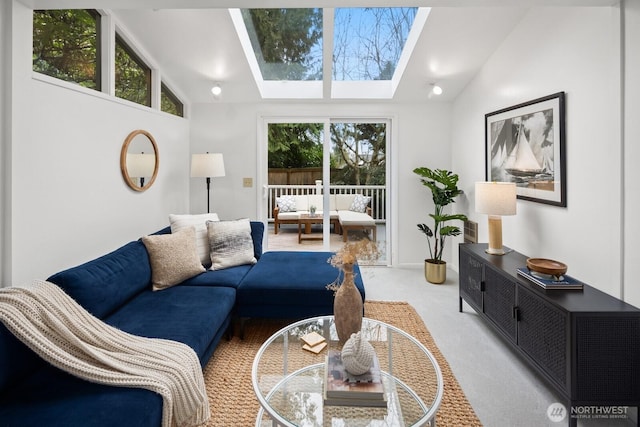 living room featuring light colored carpet, vaulted ceiling with skylight, and plenty of natural light