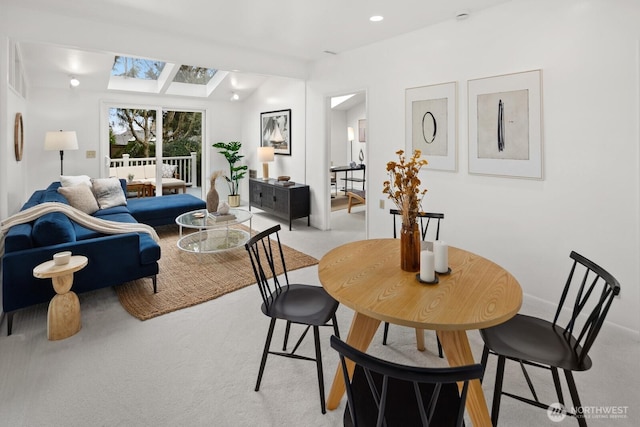 dining space with recessed lighting, light carpet, and a skylight