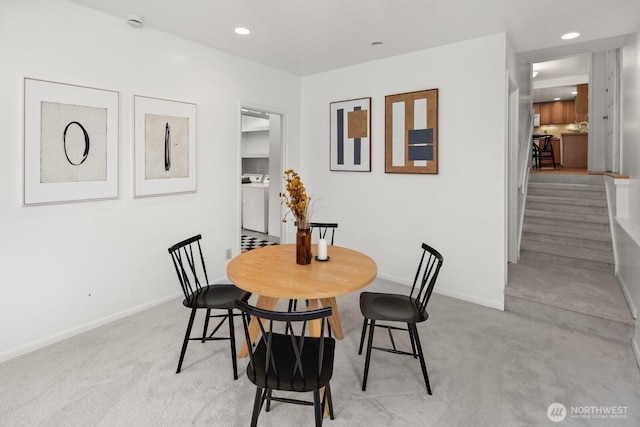 dining space with washer / clothes dryer, recessed lighting, baseboards, and light carpet