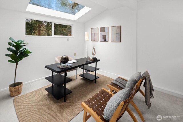 office area featuring baseboards, vaulted ceiling with skylight, and carpet flooring