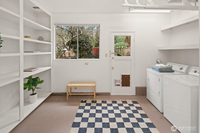 clothes washing area with visible vents, laundry area, and washing machine and clothes dryer