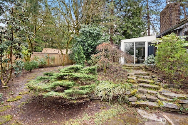 view of yard with fence and a sunroom