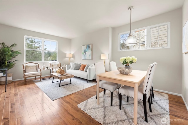 dining space featuring baseboards and wood finished floors