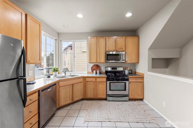 kitchen featuring light tile patterned floors, recessed lighting, a sink, light countertops, and appliances with stainless steel finishes