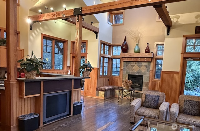 living room with beamed ceiling, wainscoting, and a tile fireplace