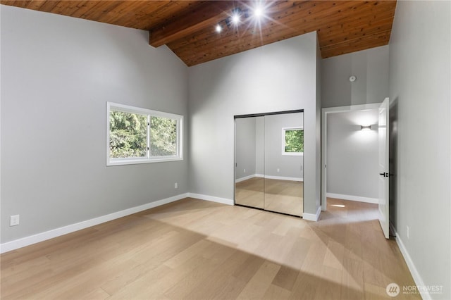 unfurnished bedroom with beam ceiling, light wood finished floors, wooden ceiling, and baseboards